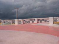 the concrete walkway and sky is very dramatic in this photo the street is painted pink