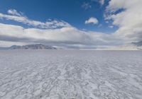 the snow covered desert looks deserted and barren at the bottom of it, with mountains in the distance