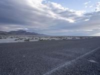 a picture of a desert scene on an empty road from the perspective angle of a vehicle