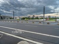 a bike path near a road in front of a big building with many windows on it