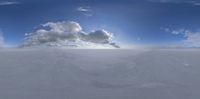a snow boarder is seen above a very large cloud in the sky by some snowy ground