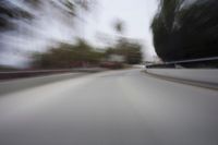 a fast moving shot of a car driving across a bridge over water and bridge above it