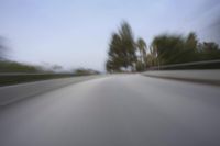 a fast moving shot of a car driving across a bridge over water and bridge above it