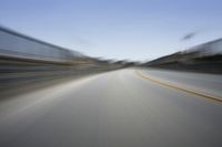 a fast moving shot of a car driving across a bridge over water and bridge above it