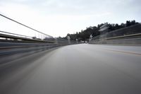 a fast moving shot of a car driving across a bridge over water and bridge above it