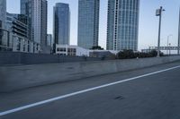 a car is driving past tall skyscrapers on the freeway outside a city center building