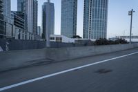 a car is driving past tall skyscrapers on the freeway outside a city center building