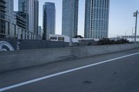 a car is driving past tall skyscrapers on the freeway outside a city center building