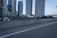 a car is driving past tall skyscrapers on the freeway outside a city center building