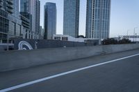 a car is driving past tall skyscrapers on the freeway outside a city center building