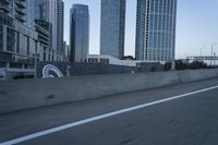 a car is driving past tall skyscrapers on the freeway outside a city center building