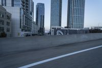 a car is driving past tall skyscrapers on the freeway outside a city center building