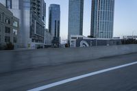 a car is driving past tall skyscrapers on the freeway outside a city center building