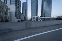 a car is driving past tall skyscrapers on the freeway outside a city center building