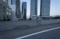 a car is driving past tall skyscrapers on the freeway outside a city center building