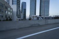 a car is driving past tall skyscrapers on the freeway outside a city center building