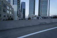 a car is driving past tall skyscrapers on the freeway outside a city center building