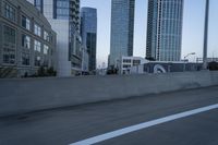 a car is driving past tall skyscrapers on the freeway outside a city center building