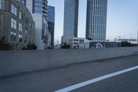 a car is driving past tall skyscrapers on the freeway outside a city center building