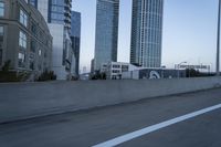 a car is driving past tall skyscrapers on the freeway outside a city center building