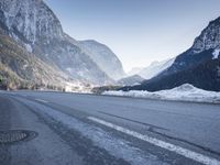 a car drives down a mountain road in the alpss next to the town of greifgene