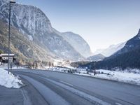 a car drives down a mountain road in the alpss next to the town of greifgene