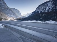a car drives down a mountain road in the alpss next to the town of greifgene