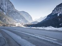 a car drives down a mountain road in the alpss next to the town of greifgene