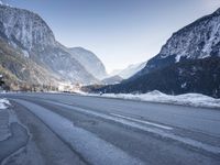 a car drives down a mountain road in the alpss next to the town of greifgene
