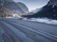 a car drives down a mountain road in the alpss next to the town of greifgene