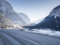 a car drives down a mountain road in the alpss next to the town of greifgene