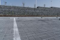 a paved parking lot near brick walls and a stone wall fence surrounding it with a pole
