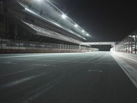 empty stadium in night with empty floor and street lights up above the field, as well as overhangs