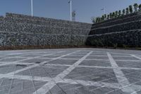 an image of a stone walled outdoor seating wall with a flag pole in the distance