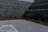 a stone wall with a white line of arrows on it is in the background of another structure