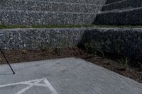 a stone wall with a white line of arrows on it is in the background of another structure