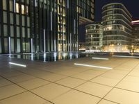 a night view of a pool near a building with a television tower in the background