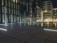 a night view of a pool near a building with a television tower in the background