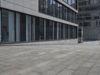 a city street with a stone sidewalk in front of it and two buildings in the background