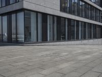 a city street with a stone sidewalk in front of it and two buildings in the background