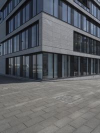 a city street with a stone sidewalk in front of it and two buildings in the background