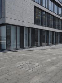 a city street with a stone sidewalk in front of it and two buildings in the background