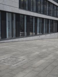 a city street with a stone sidewalk in front of it and two buildings in the background