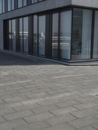 a city street with a stone sidewalk in front of it and two buildings in the background