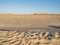 there is sand in the parking lot of an airport with a stop out sign painted on it