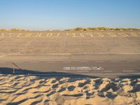 there is sand in the parking lot of an airport with a stop out sign painted on it