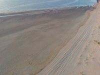 an aerial view of a beach that is empty except for people to walk around it