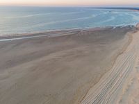 an aerial view of a beach that is empty except for people to walk around it