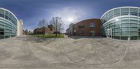 a spherical view of a public building and parking lot at dusk with no cars on the street