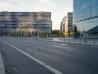 an empty street with buildings in the background at sunset of a city street at dusk